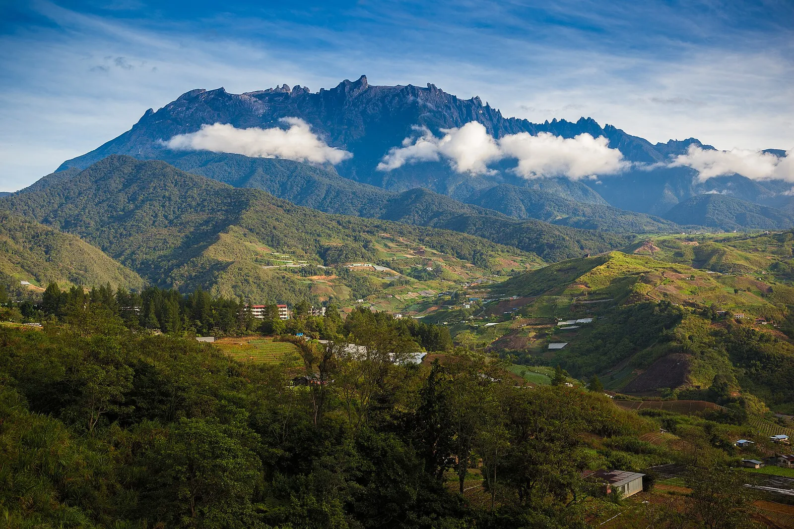 Mount Kinabalu above the farms and hills of Kundasang on a clear morning