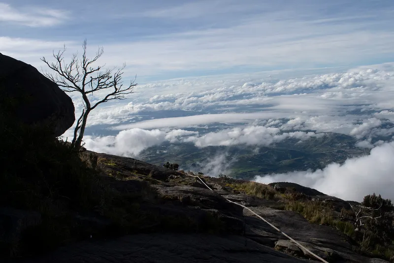 Guide rope on a granite slope high on Mount Kinabalu, with a sea of clouds below